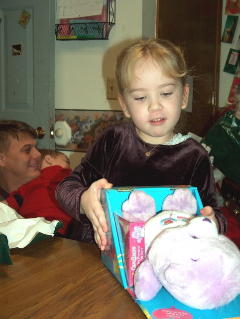 Kayla opening her gift from Santa.