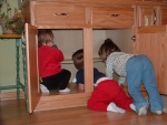 Brandon and some neighbor girls playing in a cupboard.